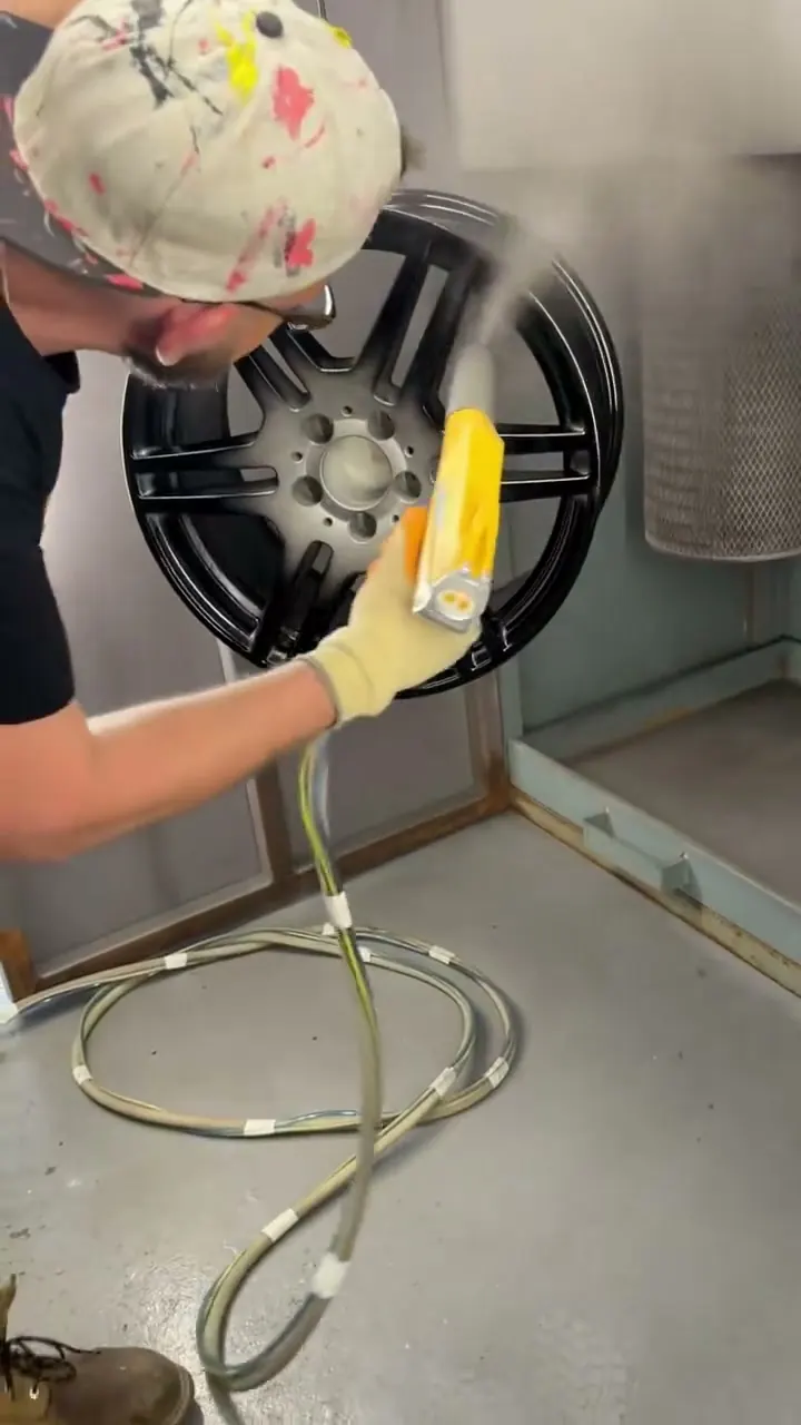 South Wales Alloys technician powder coating an AMG alloy wheel gloss black in the spray booth